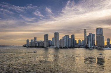 Miami, Florida, ABD - 29 Temmuz 2023: Geniş açı. Akşam 19: 44 'te Brickell Key Adası' ndaki binaların üzerinde güneş batarken nehir ağızından kıtalararası otele kadar.