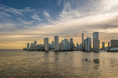 Miami, Florida, ABD - 29 Temmuz 2023: Geniş açı. Akşam 19: 45 'te Brickell Key Adası' ndaki binaların üzerinde nehir ağzı ve kıtalararası oteli geçtikten sonra gün batımı bulutları.