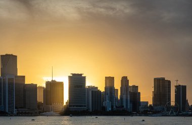 Miami, Florida, ABD - 29 Temmuz 2023: Biscayne Bulvarı 4 / 6 'nın arkasındaki zemin katı güneş, Bayfront Park ve Bay' ın arkasındaki yüksek modern binalar, kıtalararası otelden Ferris Wheel 'e kadar sıralanır.