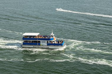 Miami, Florida, ABD - 29 Temmuz 2023: Bayridetours Island Wind teknesi yeşil liman suyuna yakın. Güvertede bir sürü insan var.