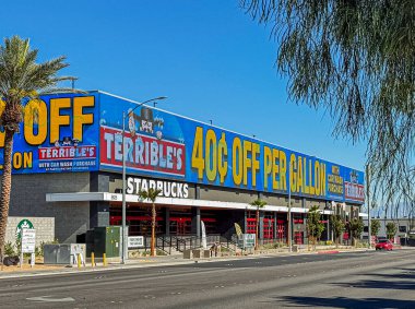 Las Vegas, NV, ABD - 12 Mayıs 2024: Mavi gökyüzü altındaki Allegiant Stadyumu 'nun karşısındaki Starbucks Kafe' nin üzerinde dev elektronik korkunç benzin istasyonu tabelası