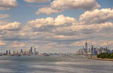 New York, New York, ABD - 1 Ağustos 2023 Upper Bay 'den Hudson Nehri girişi. New Jersey batı ve Manhattan doğu şehirleri ve gökdelenleri. Suda bir sürü mavna ve tekne var. Yeşil Brooklyn kıyısı