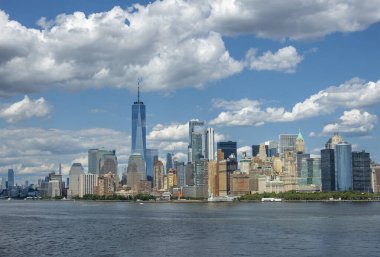 New York, New York, ABD - 1 Ağustos 2023: Panorama, Manhattan Güney Hudson nehir kıyıları ve güney ucunda mavi bulutlar altında kentsel gökdelenler var. Battery Park reklamları yeşil 