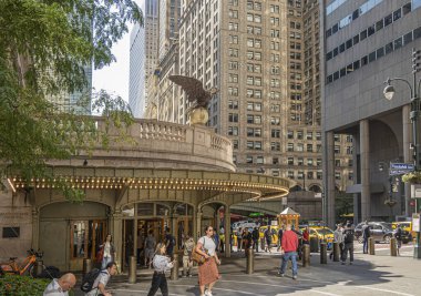 New York, NY, USA - August 2, 2023: Grand Central Terminal corner Vanderbilt Ave and east 42nd street. Bald eagle statue on top of golden globe. Pedestrians and yellow taxis in front clipart