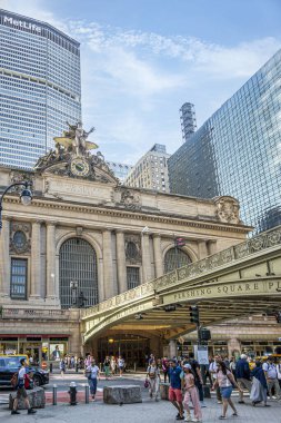 New York, New York, ABD - 2 Ağustos 2023: Portre, Merkür heykeli Grand Central Terminal ana girişinin üstünde. Kanatlı şapkalı gezginlerin tanrısı, bir Petasos. Saat, sokak tabelaları, köprü ve Metlife binası