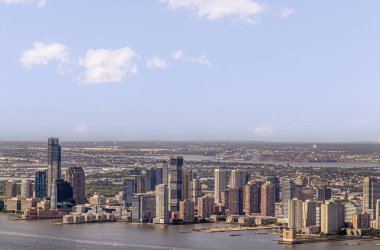 New York, New York, ABD - 2 Ağustos 2023 Hyatt Regency rıhtımından Hudson Nehri 'nin kuzeyine Hollanda tünel iskelesini ve mavi bulutların altındaki havalandırma bacasını geçerek. Empire State Binası 'ndan görüldü.