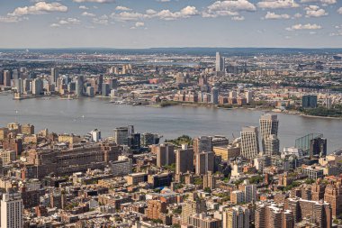 New York, New York, ABD - 2 Ağustos 2023 Hollanda tünel rıhtımından Hudson Nehri 'nin kuzeyinden Castle Point' e kadar mavi bulutların altında. Empire State Binası 'ndan görülmüş. Şehir. her iki kıyıda da orman