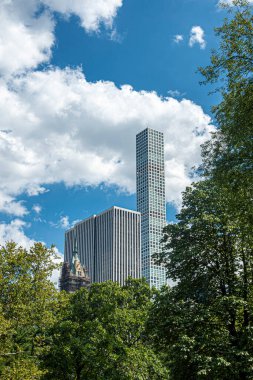 New York, New York, ABD - 2 Ağustos 2023: 432 Park Bulutları 'nın en yüksek binası Central Park' ın yeşil yeşillikleri üzerinde yükseliyor. Sherry Netherland Otel 'in tarihi kulesi