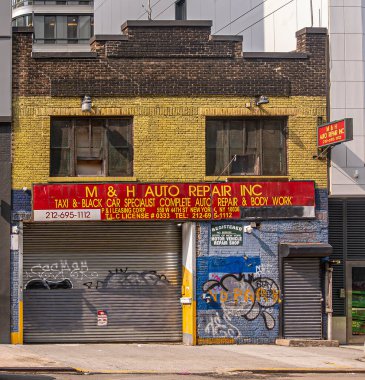 New York, New York, ABD - 3 Ağustos 2023 W44. caddedeki Oto Tamirhanesi cephesi. Duvarda ve kapıda grafiti var.