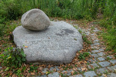 New York, NY, USA - August 4, 2023: WWII Norwegian Merchant Marine and Navy memorial stone, in Battery Park, closeup. gray stone among green foliage