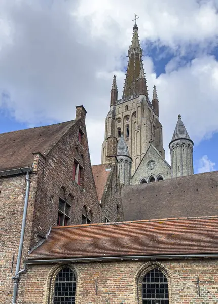 stock image Brugge, Flanders, Belgium - June 22, 2024: Tower of Notre-Dame, Onze Lieve Vrouwe Cathedral seen from Eleonora Verbekehof, Saint Jan Hospital courtyard