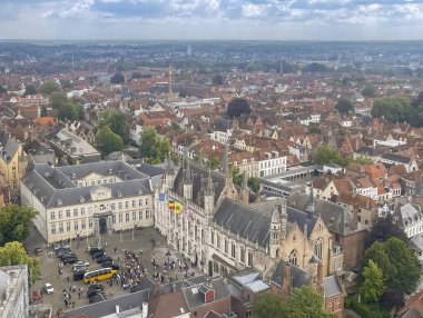 Brugge, Flanders, Belgium - June 22, 2024: Burg square from Halletoren with its historical buildings, set in urban jungle, cityscape of roofs and houses clipart