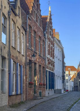 Brugge, Flanders, Belçika - 23 Haziran 2024: Middelburgstraat 'ın köşesinden, mavi gökyüzünün altından. İkamet evleri ön sırada.