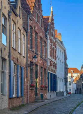 Brugge, Flanders, Belçika - 23 Haziran 2024: Middelburgstraat 'ın köşesinden, mavi gökyüzünün altından. İkamet evleri ön sırada.