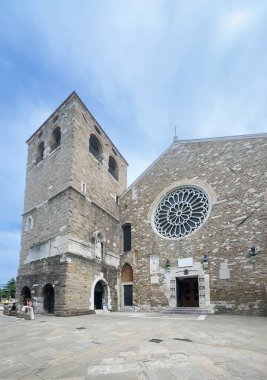 Trieste, İtalya - 27 Haziran 2024: Cattedrale di San Giusto Martire, San Giusto Kalesi Katedrali. Mavi bulutlara karşı çan kulesi ve gül pencereli ön cephe