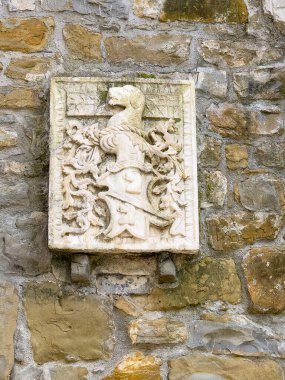 Trieste, İtalya - 27 Haziran 2024: Tarihi San Giusto Kalesi. Köpek resmi olan beyaz taş arma.