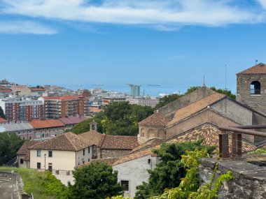 Trieste, İtalya - 27 Haziran 2024: Tarihi San Giusto Kalesi. Cattedrale di San Giusto Martire 'ın batısına, mavi bulutların altındaki Katedral' e bakıyorum. Şehir manzarası ve Adriyatik Denizi 'ndeki gemiler