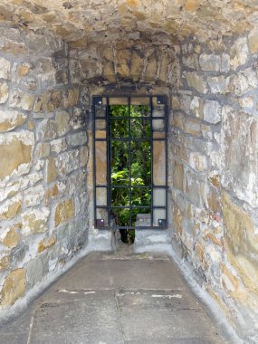 Trieste, İtalya - 27 Haziran 2024: Tarihi San Giusto Kalesi. Topun durduğu surlarda nokta, şimdi boş ve pencere artık metal ızgaralarla korunuyor. 