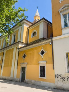Trieste, İtalya - 27 Haziran 2024: Chiesa S. Antonio Vecchio Piazza Attilio Hortis 'ten görüldü. Sarı cepheler ve gökyüzüne bakan kule