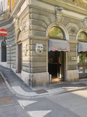 Trieste, İtalya - 29 Haziran 2024: Tiyatronun karşısındaki Rossetti barı aynı isimle. Büyük maskeli ön cephe ve giriş tarihi bir duvar tasarladı.