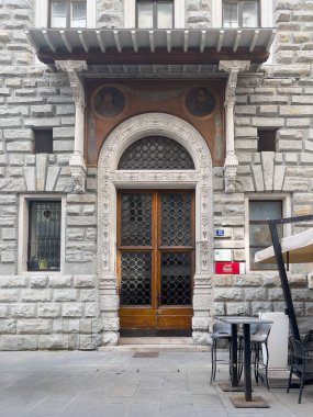 Trieste, İtalya - 29 Haziran 2024 Via Trenta Ottobre anıtsal giriş kapısı üzerinde fresk ve iki eski insan resmi