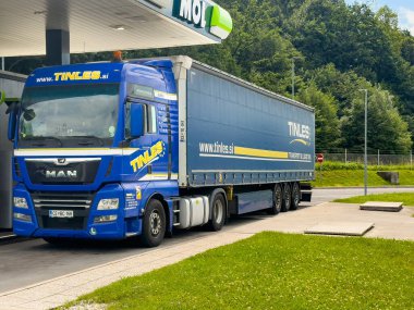Radovljica, Slovenya - 28 Haziran 2024: E61 boyunca MOL benzin istasyonunda Tinles.si şirketinin büyük MAN karavan kamyonu