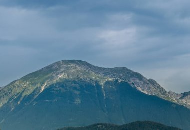 Radovljica, Slovenya - 28 Haziran 2024: E61 boyunca MOL benzin istasyonunun arkasındaki dağ.