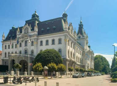 Ljubljana, Slovenya - 28 Haziran 2024: Mavi gökyüzünün altındaki Kongress meydanının sonundaki Slovenya tarihi üniversite binası. Arabalar ve motorsikletler