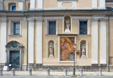 Ljubljana, Slovenia - June 28, 2024: Art on South facade of Saint Nicholas Cathedral. Painting of Archangel Gabriel telling Maria the Holy Ghost is impregnating her with Jesus. Statues of Saints Joseph, Hermagoras, Fortunatus clipart