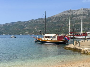 Korcula, Hırvatistan - 30 Haziran 2024: Leute MOJ özel yelkenli limanda. Arkadaki ana dağ sırası..