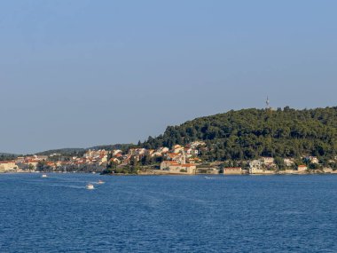 Korcula, Hırvatistan - 30 Haziran 2024: St. Nicholas Dominik Manastırı üzerinde orman tepe ile kasabanın batı kıyı şeridi boyunca uzanır. Tüm sahil şeridi boyunca surların istihkam köşelerine kadar uzanan şehir manzarası. Denizde gemiler