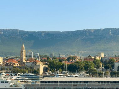 Split, Hırvatistan - 1 Temmuz 2024: Saint Domnius Katedrali ile şehir merkezi tarihi. Mavi gökyüzünün altındaki sıradağlarda. Limanda bir sürü yat var.