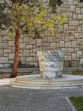 Split, Hırvatistan - 1 Temmuz 2024: Klis Kalesi. Şatonun aşağısındaki oyun parkında Ulica Iza Grada kırsal sokağı boyunca uzanan dev mermer bir saksı.