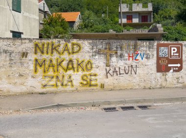 Split, Hırvatistan - 1 Temmuz 2024: Klis Kalesi. Grafiti diyor ki, kim bilir, haçın kenarında, Ulica Iza Grada Caddesi 'ndeki kalenin duvarına boyanmış.. 