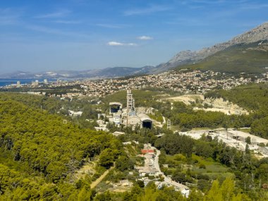 Split, Hırvatistan - 1 Temmuz 2024: Cemex çimento arkasında şehir bulunan yeşil arazide çalışıyor