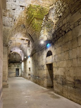 Split, Croatia - July 1, 2024: Historic Diocletian Cellars and palace. Long hallways with bowed ceilings, one overgrown with moss. Openings to rooms and side walkways clipart