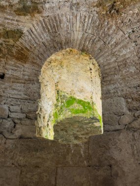 Split, Croatia - July 1, 2024: Historic Diocletian Cellars and palace. Open air niche in wall full of cracks, holes and some moss patches clipart