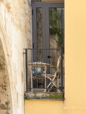 Split, Hırvatistan - 1 Temmuz 2024: Şehir merkezi tarihi. Diocletian Palace 'ın dışındaki dar sokaktaki apartmanda iki sandalye ve masa olan küçük bir balkon..