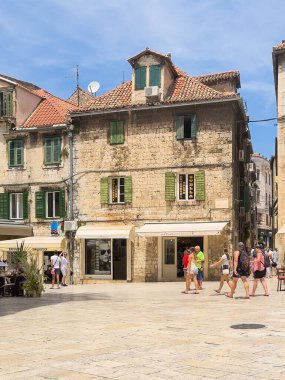 Split, Hırvatistan - 1 Temmuz 2024: Şehir merkezi tarihi. Radiç Kardeşler Meydanı 'nın NW tarafı Ul' un köşesindeki dondurmacı Gelateria aMare 'yi gösteriyor. Pavla Subica sokağı. Ayakkabılar ve güneş gözlükleri için iki mağaza daha. Hepsi de antika binalarda. Yayalar