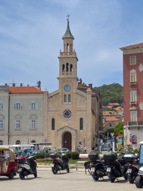 Split, Hırvatistan - 1 Temmuz 2024: Sahil şeridi. Franje Tumana, kare, su kenarından, kiliseden ve St. Francis Manastırı 'ndan ve diğer tarihi binalardan görülen trafik ve halk otobüsü mavi bulutların altında.
