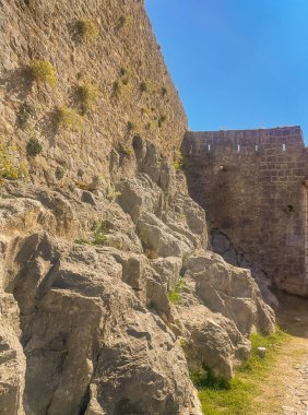 Split, Hırvatistan - 1 Temmuz 2024: Klis Kalesi kayalar üzerine inşa edildi. Mavi bulutların altındaki duvarda bitkiler