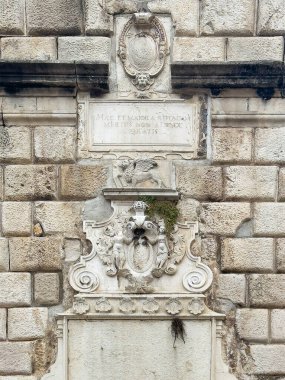 Kotor, Karadağ - 2 Temmuz 2024: Eski tarihi kentin ana girişini geçince saat kulesi. Kanatlı aslan ve heykel Venedik kökenini kutluyor.