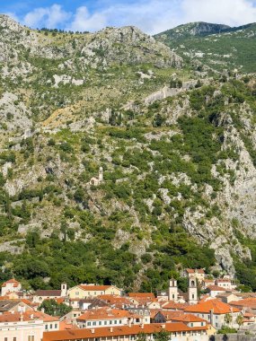 Kotor, Karadağ - 2 Temmuz 2024: Aziz Tryphon Katedrali Eski tarihi kent merkezindeki kırmızı çatılı binaların üzerinde. Rocky Dağı arka tarafı kuşattı. Çaresi ve şatosu olan kilisemiz.
