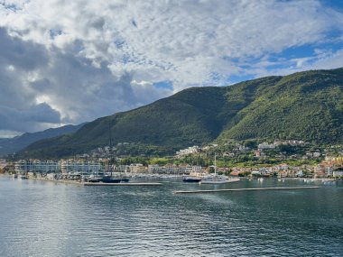 Kotor Körfezi, Karadağ - 2 Temmuz 2024: Adriyatik Denizi 'nden körfezin girişinde yoğun bulutların altında Portonovo. Liman tesisleri ve otelleri olan kıyı şeridi