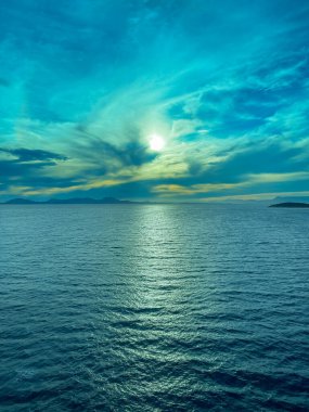 İyonya, Yunanistan - 3 Temmuz 2024: Ufuktaki bazı adaların şekilli mavi gün batımı