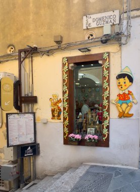 Taormina, Sicilya, İtalya - 5 Temmuz 2024: Bir sürü heykelciği olan hediyelik eşya dükkanı. Pinokhio da onlardan biri. Corso Umberto ve Via San Domenico 'nun köşesinde.