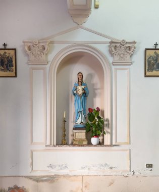 Taormina, Sicilya, İtalya - 5 Temmuz 2024: Santa Domenica Kilisesi. Bebek İsa 'nın olduğu Bakire Meryem Anıtı. Yeşil ve kırmızı bitki. Bir mum