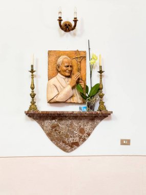 Taormina, Sicilya, İtalya - 5 Temmuz 2024: Santa Domenica Kilisesi. Papa 2. John Paul haç tutuyor ve kutsal jest heykelini mumlar ve sarı çiçeklerle yapıyor.