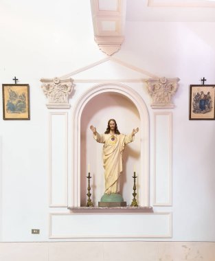 Taormina, Sicilya, İtalya - 5 Temmuz 2024: Santa Domenica Kilisesi. Kutsal Yürek Anıtı iki mumla dolu. İsa kollarını ileri açıyor.