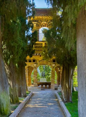 Taormina, Sicilya, İtalya - 5 Temmuz 2024: Villa Comunale di Taormina tarihi bina restore edildi. Savaş anıtı, Monumento ai Caduti, dipten bakıldığında yeşil yapraklar.